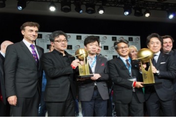Mazda Motor North American Operations team holding up trophies after winning both 2016 World Car of the Year and Car Design of the Year awards